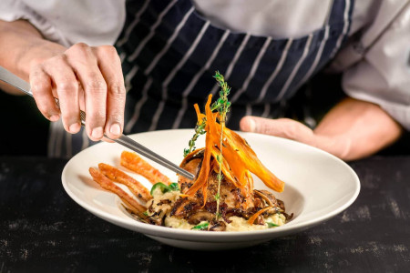 private chef serving fish dish in villa