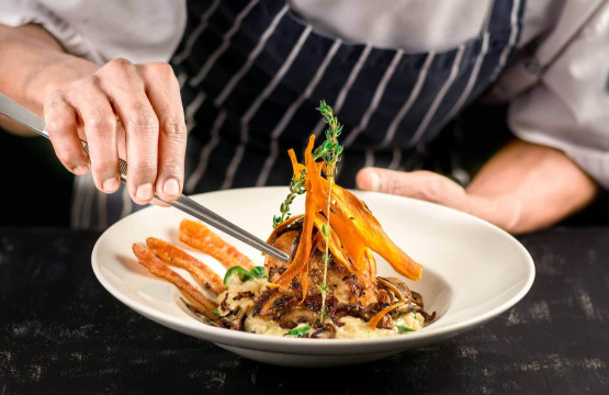 private chef serving fish dish in villa