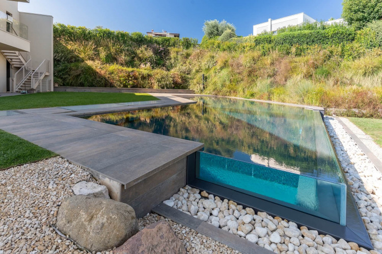 Pool area at Villa Belvedere with loungers and lake view