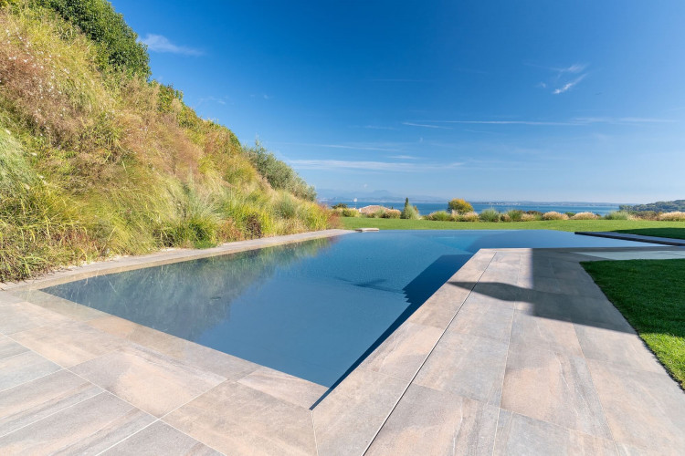 Pool area at Villa Belvedere with loungers and lake view